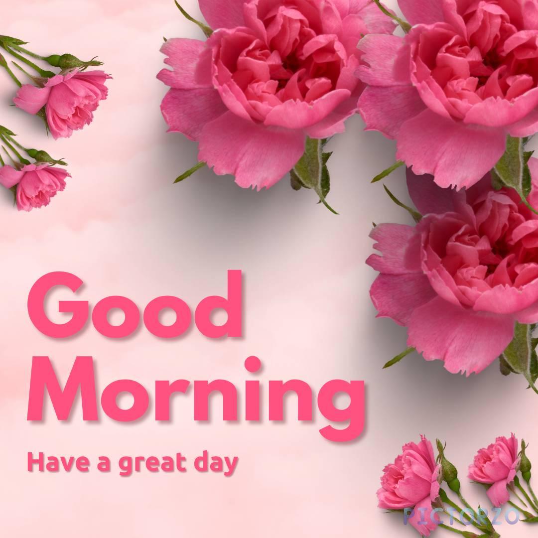 A good morning image with pink flowers in a vase on a wooden table. The text Good Morning, Have a great day! is superimposed on the image in a cursive font