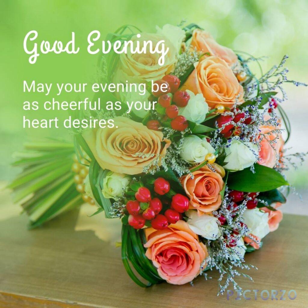 A bouquet of flowers sitting on a table with the text Good Evening and May your evening be as cheerful as your heart desires
