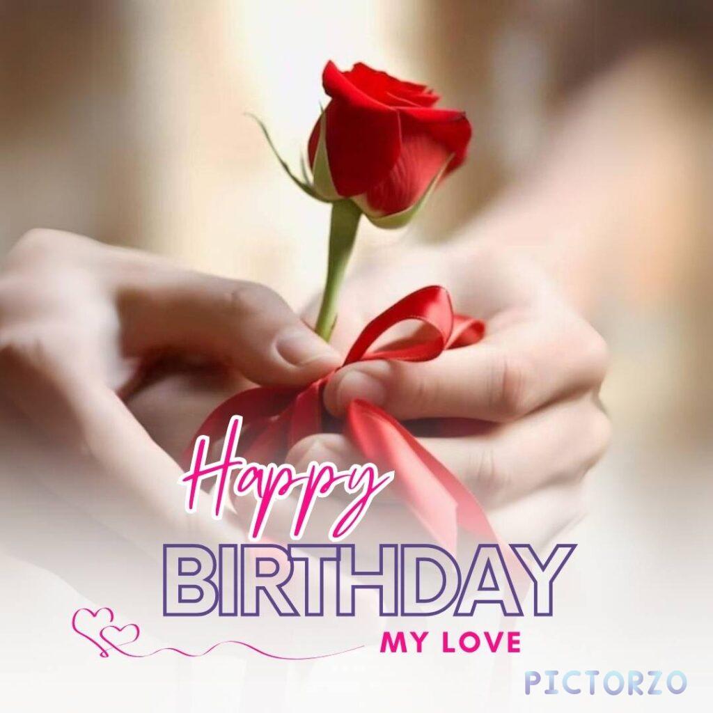 A close-up photo of a red rose held in someone's hands. Text on the image reads Happy Birthday My Love