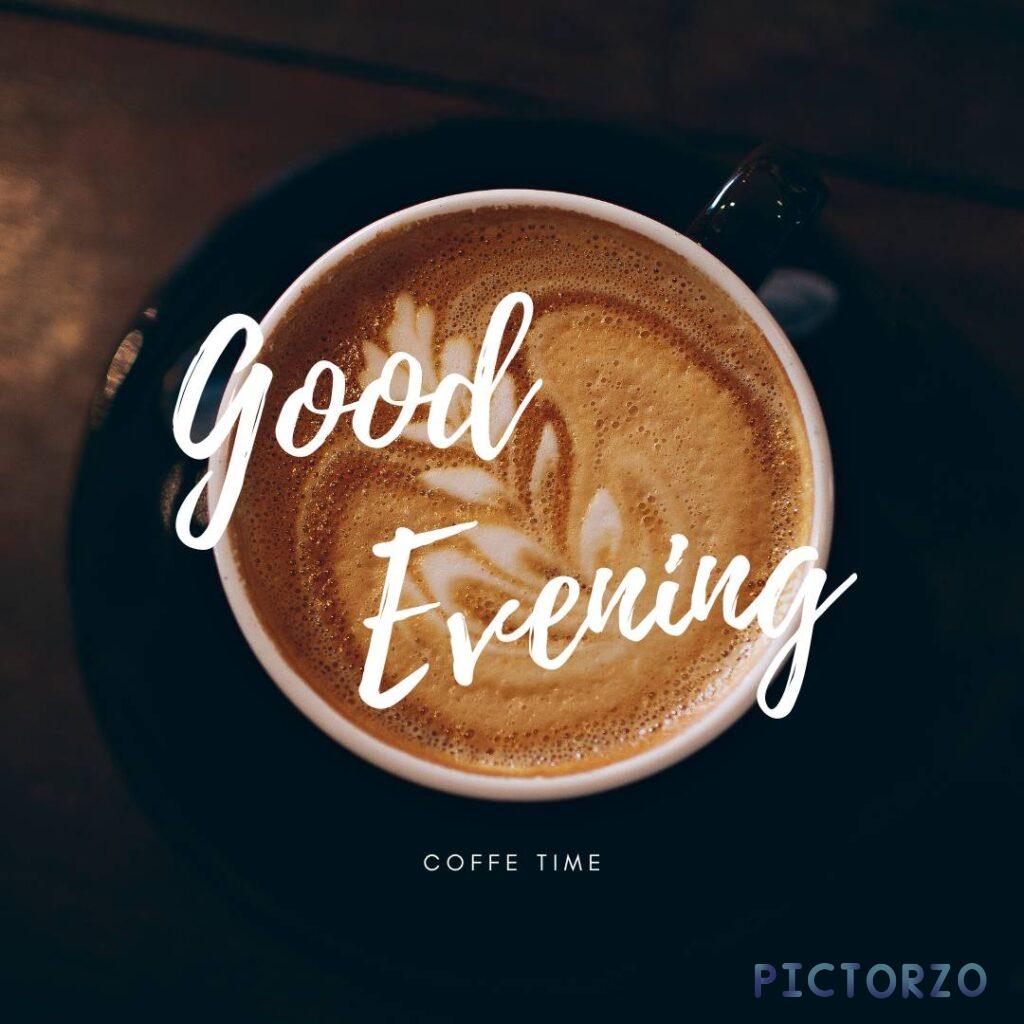 A cup of coffee with the words Good evening written on it. The cup is sitting on a wooden table, with a window in the background. The window overlooks a city skyline at evening