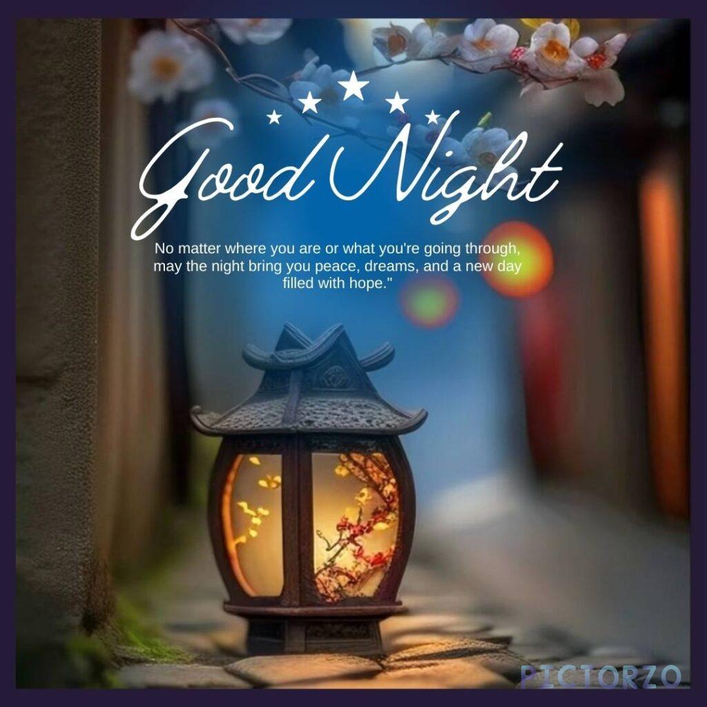 A photo of a lantern with the message "Good Night Beautiful" written on it in white paint. The lantern is sitting on a wooden table, and there are flowers and candles in the background. The image is warm and inviting, and the message is one of love and affection