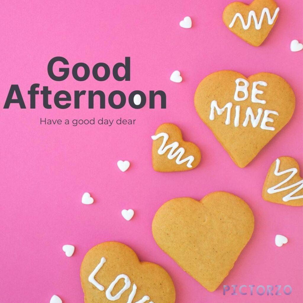 A photo of a pink heart with the text "Good afternoon" written in white letters. The heart is surrounded by heart-shaped cookies on a pink background. The image can be used to express love and affection for someone, or as a greeting card for a loved one.