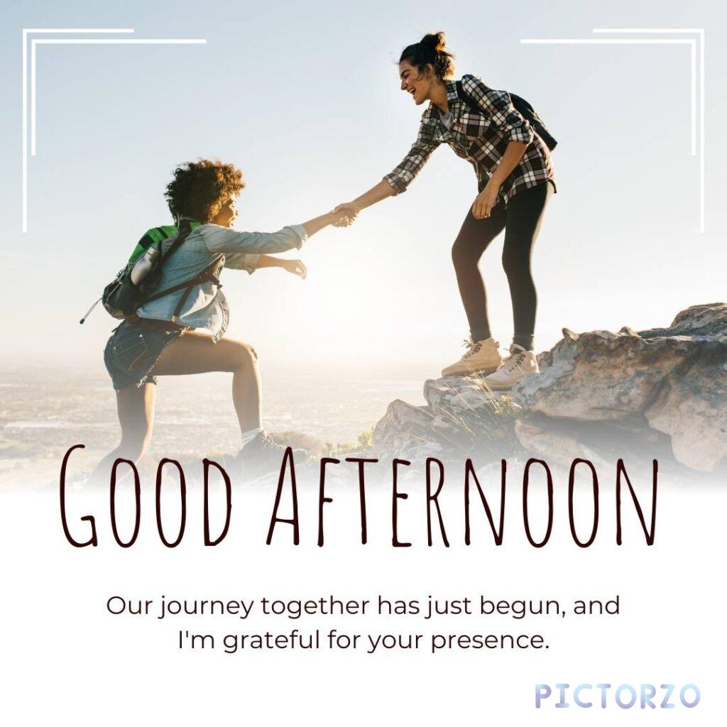 A photo of two women standing on top of a mountain, holding hands. The text on the image says Good afternoon our journey together has just begun and I'm grateful for your presence.