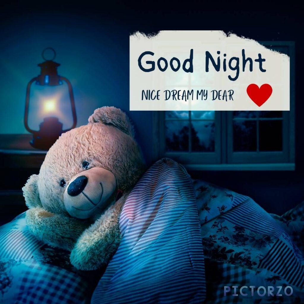A teddy bear lying in a cozy bed under a soft blanket, with the words Good night. Sleep tight and dream sweet dreams. written on a chalkboard above the bed