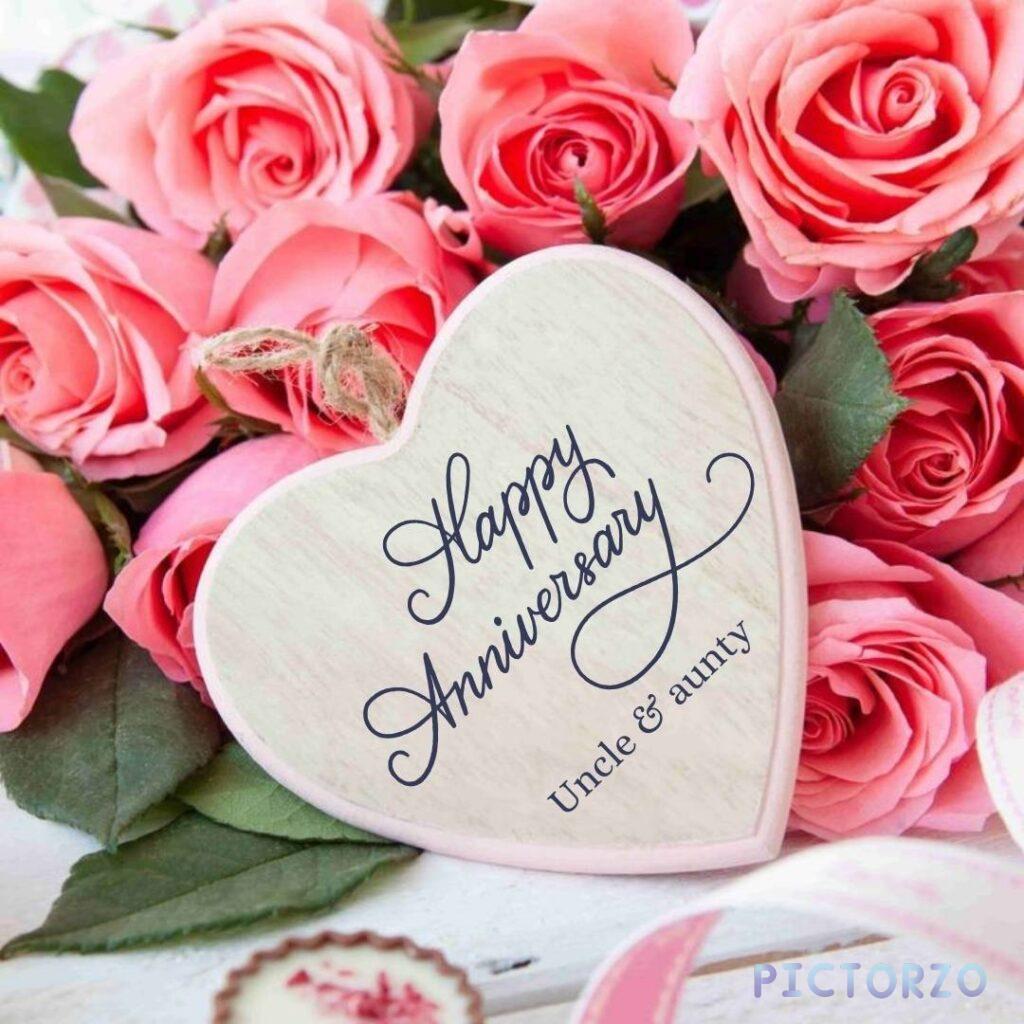 A digital greeting card with colorful text that reads Happy Anniversary Uncle & Aunty The text is positioned above a red and pink heart design